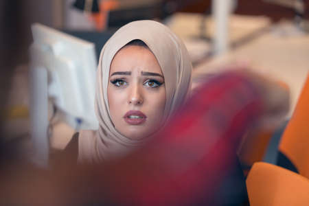 Worried businesswoman receiving a notification from a colleague in her workplace at office