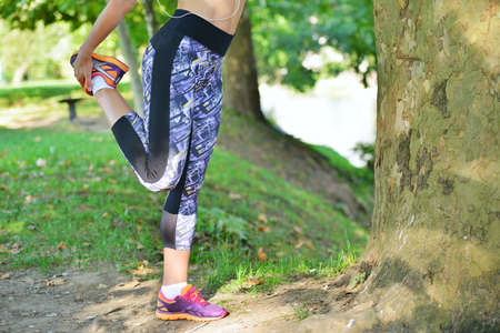 Young girl stretching before jogging at the park - outdoors.