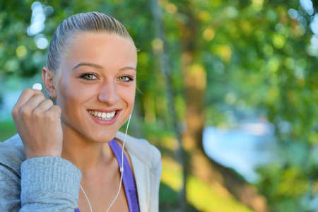 Young woman taking rest after jogging - workout at the park.