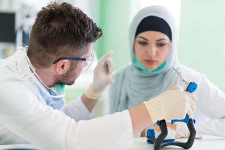 Dental prosthesis, dentures, prosthetics work. Arab students with hijab while working on the...