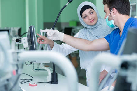 Dental prosthesis, dentures, prosthetics work. Arab students with hijab while working on the denture, false teeth, a study and a table with dental toolsの写真素材