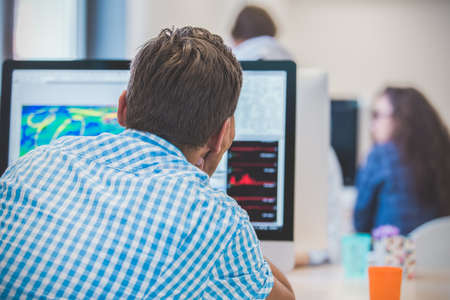 Thoughtful young programmer coding on computerの写真素材