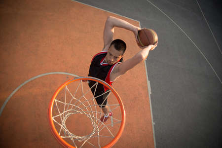 Basketball street player making a slam dunk