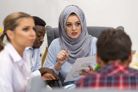 Shot of a group of young business professionals having a meeting. Diverse group of young designers smiling during a meeting at the office.の写真素材