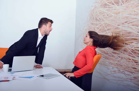 Two angry businesspeople arguing furious showing a negative growth graph at office.の写真素材