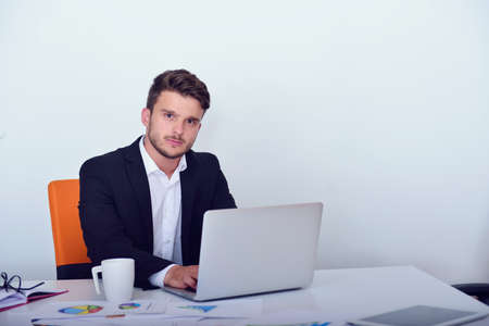 Businessman using laptop in modern startup office.の写真素材