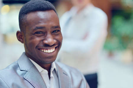 Portrait of smiling young black man in hall.