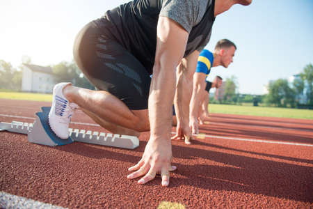 Runners preparing for race at starting blocks.の写真素材