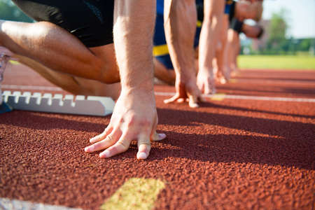 Runners preparing for race at starting blocks.の写真素材