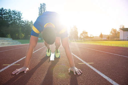 Athletic man on track starting to run. Healthy fitness concept with active lifestyle