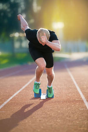Sprinter leaving starting blocks on the running track. Explosive startの写真素材