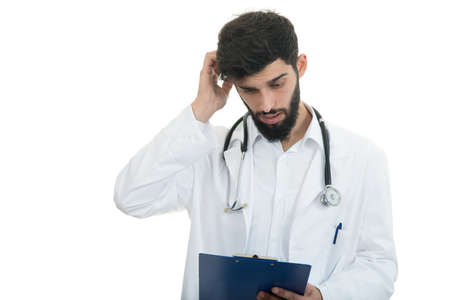 Worried young doctor with head in hand on white background.の写真素材