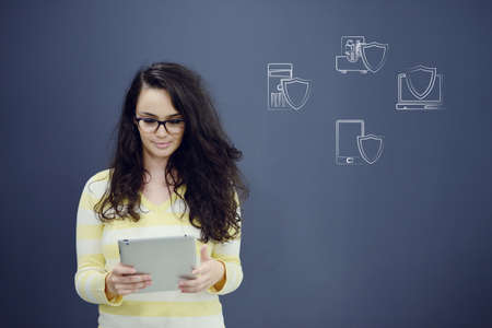 Cheerful young woman with background with drawn business chart, arrow and icons. Successful business conceptの写真素材