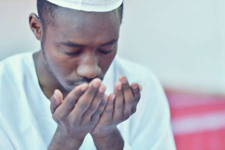 African Muslim Man Making Traditional Praying To God While Wearing A Traditional Cap Dishdashaの写真素材