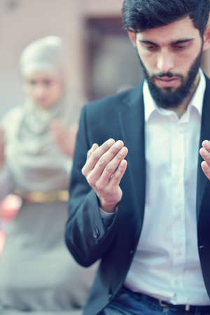 Muslim man and woman praying in mosqueの写真素材