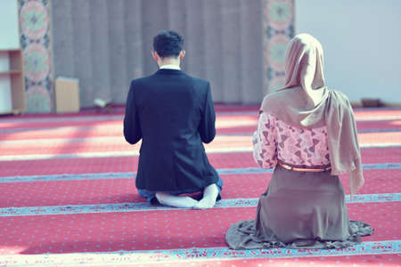 Muslim man and woman praying in mosqueの写真素材