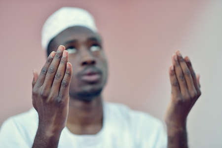 African Muslim Man Making Traditional Praying To God While Wearing A Traditional Cap Dishdashaの写真素材