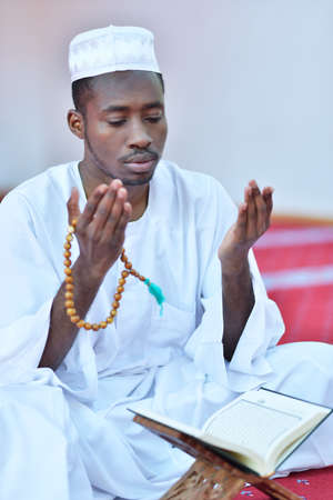 African Muslim Man Making Traditional Praying To God While Wearing A Traditional Cap Dishdasha