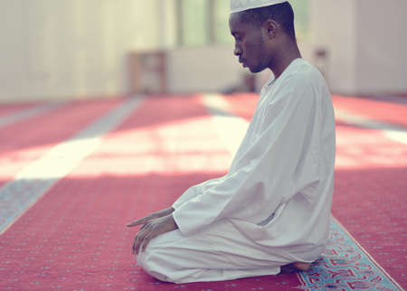 African Muslim Man Making Traditional Praying To God While Wearing A Traditional Cap Dishdashaの写真素材