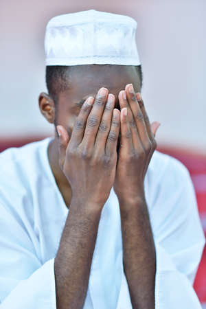 African Muslim Man Making Traditional Praying To God While Wearing A Traditional Cap Dishdasha