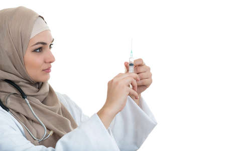 Muslim female medical doctor filling the syringe getting ready for a medical procedureの写真素材