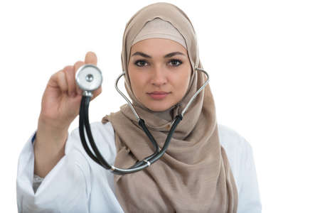 close up portrait of arab female doctor smiling while using stethoscope.の写真素材