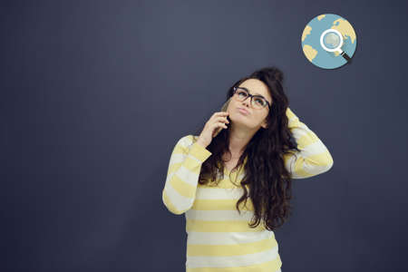 Woman talking on phone in front of background with drawn business charts and symbols