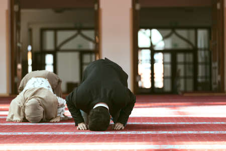 Muslim man and woman praying in mosque.の写真素材