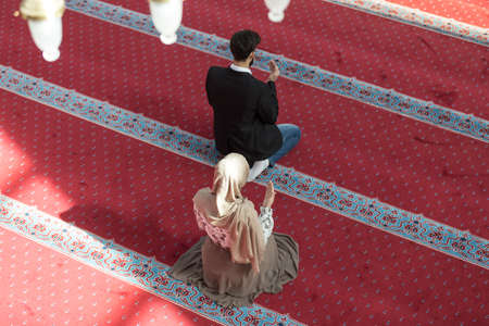 Muslim man and woman praying in mosque.の写真素材