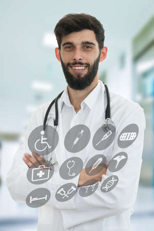 Young serious handsome bearded doctor with white coat and stethoscope. Isolated on white.の写真素材