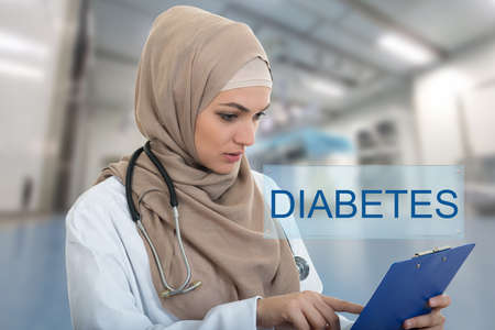portrait of worried muslim female Medical doctor holding paperclip in hospital. Diabetes sign.
