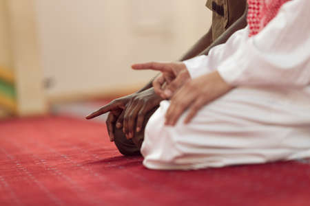 Two religious muslim man praying together inside the mosque.の写真素材