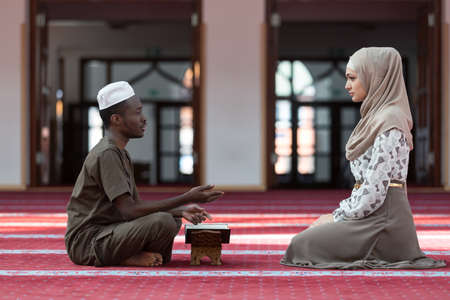 Black Muslim man and woman praying in mosque.の写真素材