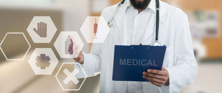 Male Doctor standing with folder, with medical symbols.の写真素材