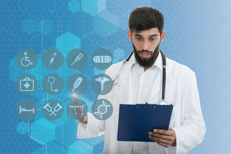 Male Doctor standing with folder, medical symbolsの写真素材