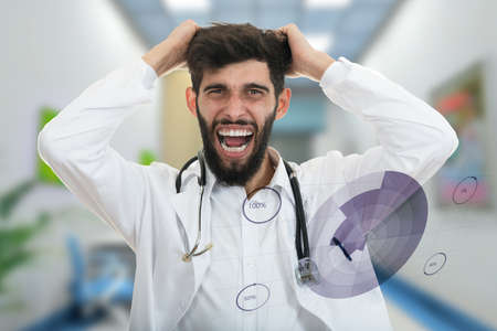 Closeup portrait of rude frustrated upset overwhelmed, angry young doctor, mad health care professional, screaming and pulling hair with medical graphs in foreground. Human face expressions, emotionsの写真素材