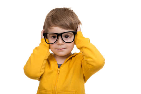 Cute schoolboy thinking idea while wearing glasses and looking at up, isolated on white background