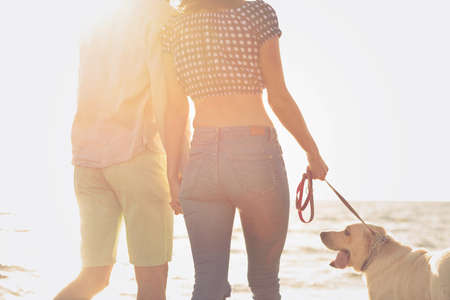 Portrait of a happy couple with dogs at the beachの写真素材