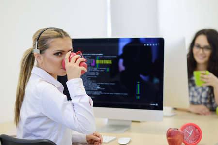 Young businesswoman on a coffee break. Using computer.