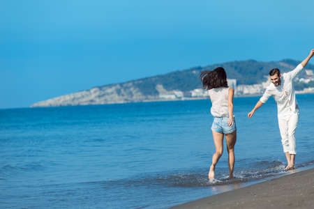 happy couple running on the beachの写真素材