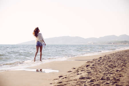 Young female enjoying sunny day on tropical beachの写真素材
