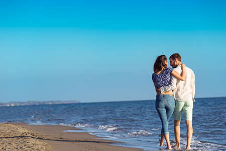 Couple walking on beach. Young happy interracial couple walking on beach.の写真素材
