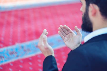 Younger Muslim man praying in colorful mosque