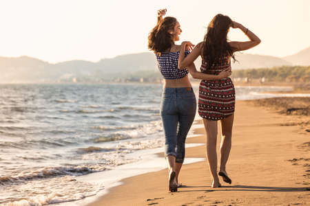 Pretty girl has a fun with her girlfriend on the beachの写真素材