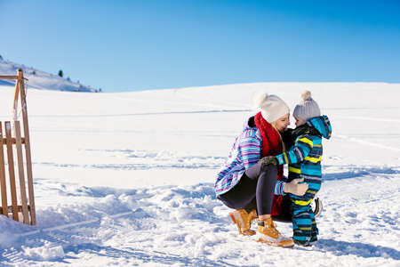 happy family mother and child daughter having fun, playing at winter walk outdoorsの写真素材