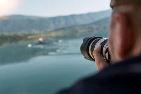 Photographer in nature taking pictures to a beautiful lakeの写真素材