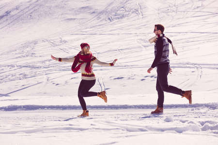 Couple having fun running down slopeの写真素材