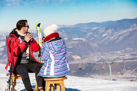 A couple is resting on lounges in picnic zone on european ski resortの写真素材