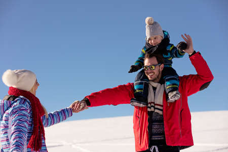 Attractive family having fun in a winter park on mountainの写真素材