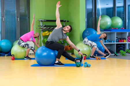 Portrait of happy group exercising on Swiss ballの写真素材